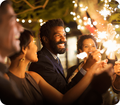Friends enjoying a festive evening with sparklers and smiles.