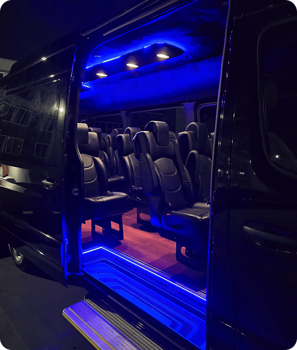 image Interior of a black vehicle with blue LED lighting showcasing multiple seats.